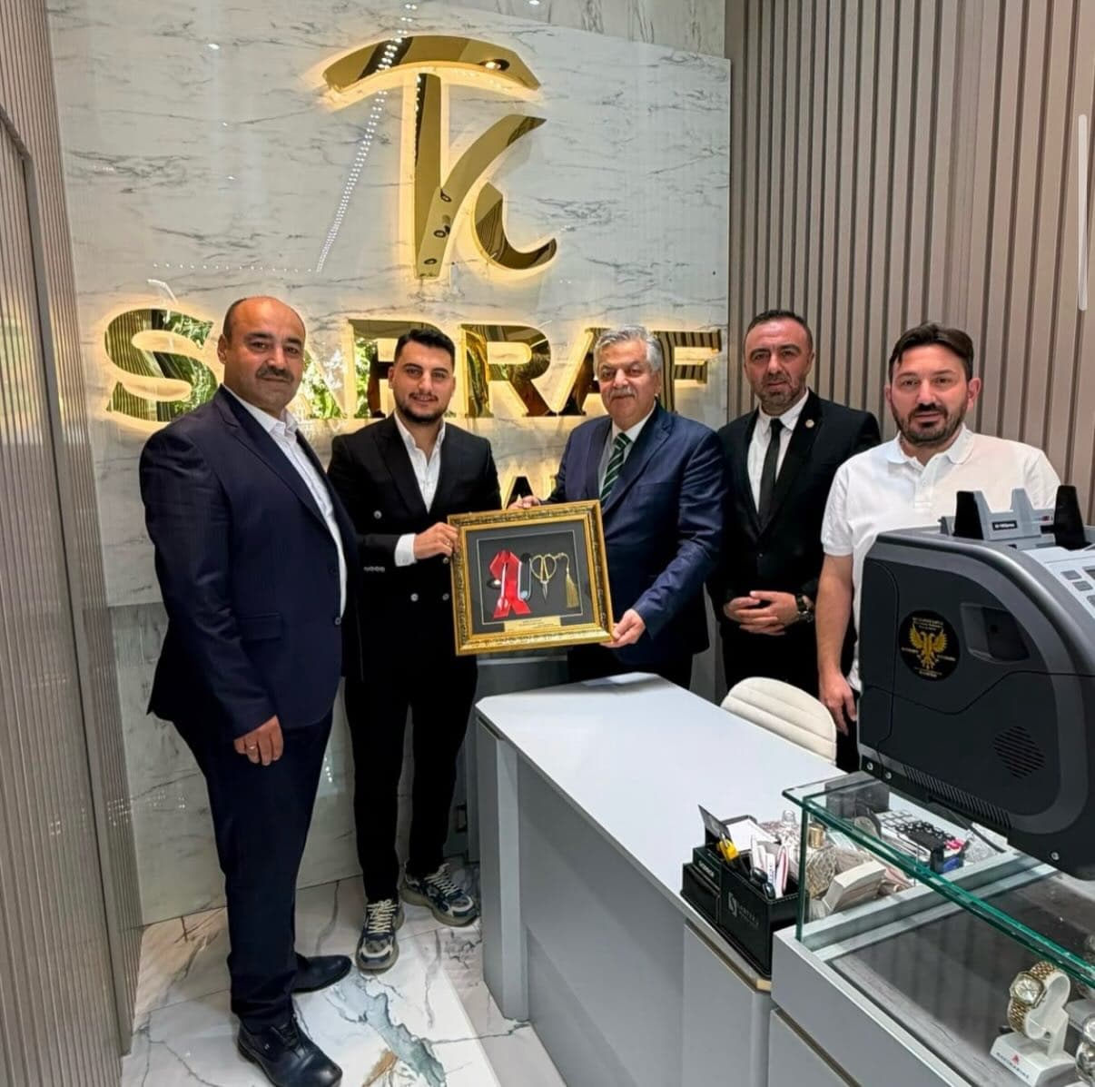 Kağan Sarraf sahibi Kağan Tanrıverdi'ye hatıra çerçevesinin takdim edilmesi